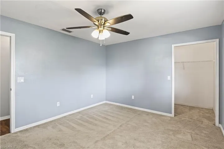 Unfurnished bedroom with carpet floors, visible vents, baseboards, a spacious closet, and a closet