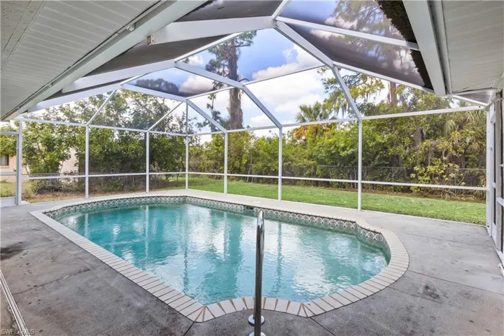 View of pool with a patio, glass enclosure, and a fenced in pool