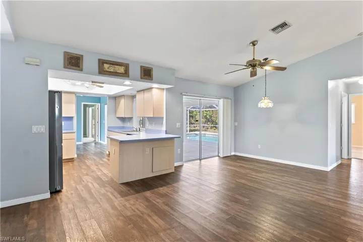 Kitchen with ceiling fan, a peninsula, dark wood-style flooring, visible vents, and light countertops