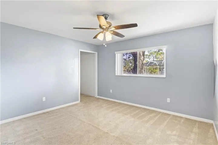 Unfurnished room with a ceiling fan, carpet, and baseboards