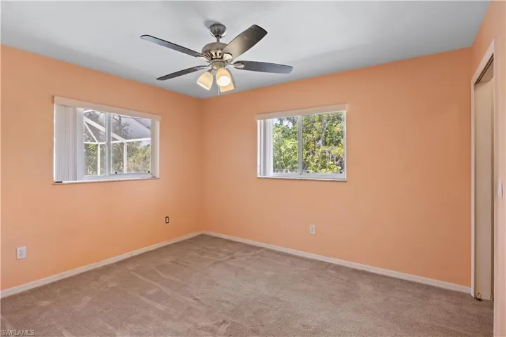 Unfurnished bedroom with ceiling fan, carpet floors, and baseboards