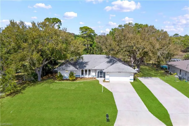 View of front of property with concrete driveway, a front yard, and a garage