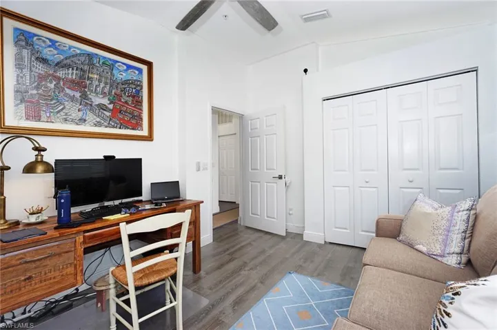 Home office featuring a ceiling fan, wood finished floors, lofted ceiling, baseboards, and visible vents