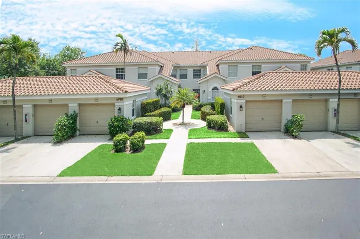 View of front facade featuring a tiled roof, concrete driveway, and stucco siding