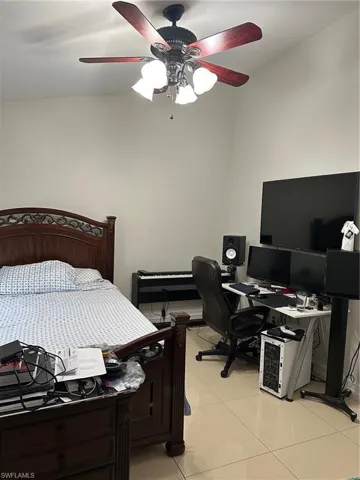 Bedroom with light tile patterned floors and ceiling fan