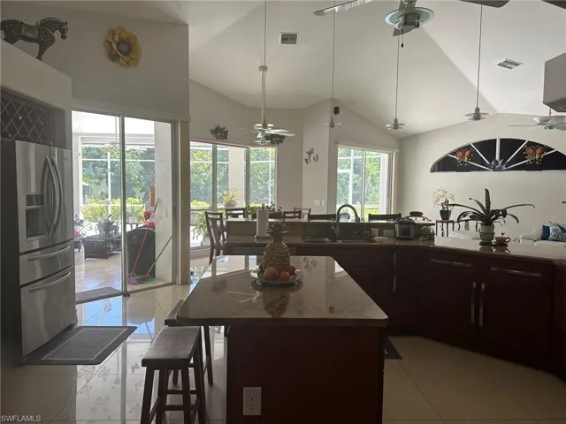 Kitchen with a sink, visible vents, stainless steel refrigerator with ice dispenser, and a ceiling fan
