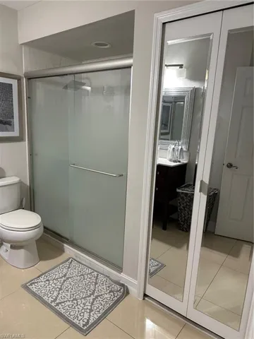 Full bathroom featuring a stall shower, tile patterned floors, toilet, and vanity