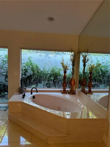 Full bathroom featuring tile patterned floors and a jetted tub