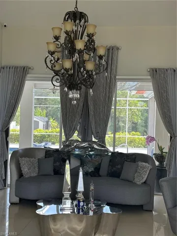 Tiled living room with a healthy amount of sunlight and a chandelier