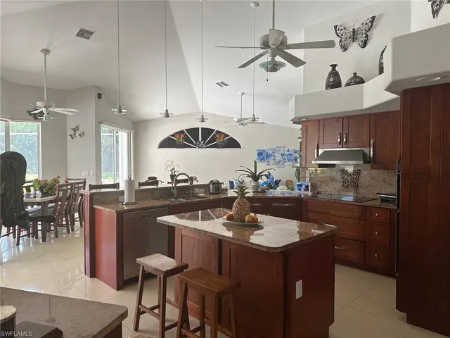 Kitchen with visible vents, a ceiling fan, under cabinet range hood, a sink, and stainless steel dishwasher