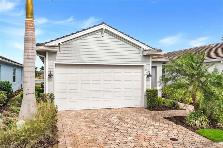 View of front of house with decorative driveway and a tiled roof