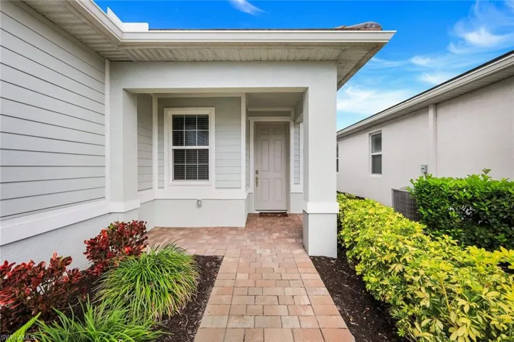 Doorway to property with a porch and stucco siding