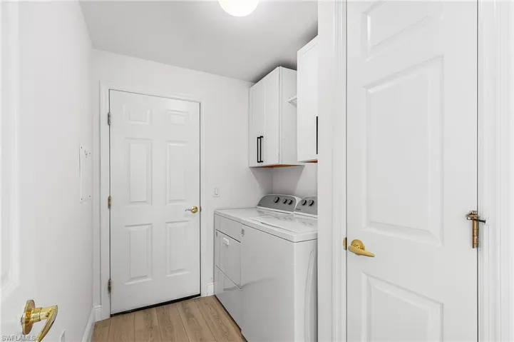 Laundry area with new cabinetry, drying bar, storage closet, access out to the garage.