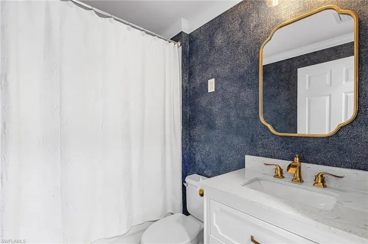 Guest bath featuring vanity and crown molding and a tub and shower combo.