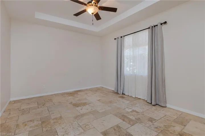 Master Bedroom with a raised ceiling and ceiling fan