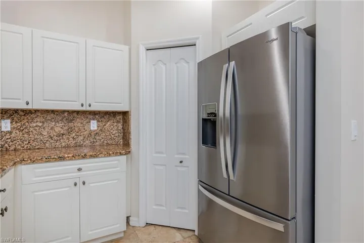 Kitchen featuring white cabinets, stainless steel refrigerator with ice dispenser