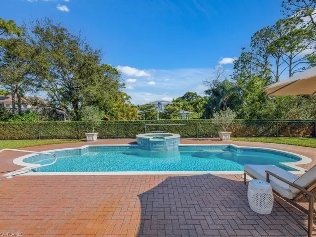 View of pool with a patio area, a fenced backyard, and a pool with connected hot tub