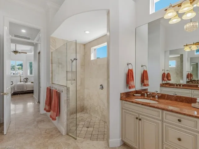 Ensuite bathroom with plenty of natural light, vanity, walk in shower, and ceiling fan