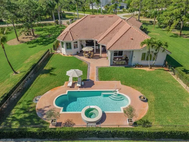 Aerial view of property and surrounding area featuring a pool