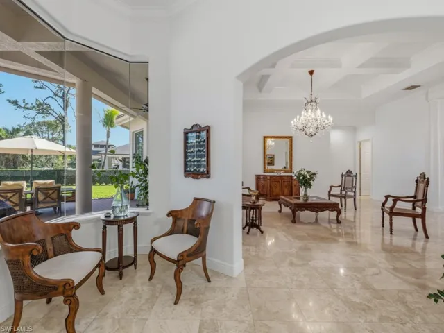 Living area featuring ornamental molding, coffered ceiling, beam ceiling, a chandelier, and a sunroom