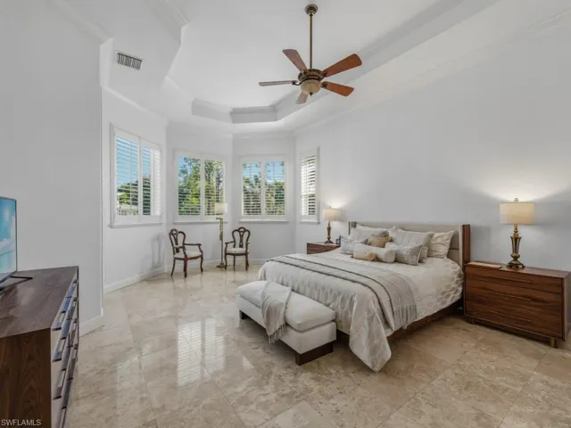 Bedroom featuring a tray ceiling, crown molding, and ceiling fan