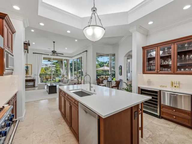 Kitchen with tasteful backsplash, glass insert cabinets, pendant lighting, beverage cooler, and recessed lighting