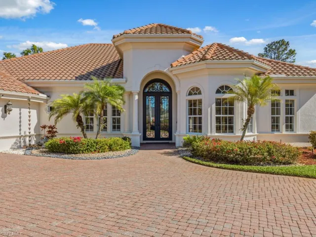 View of exterior entry with french doors, stucco siding, a tiled roof, an attached garage, and decorative driveway