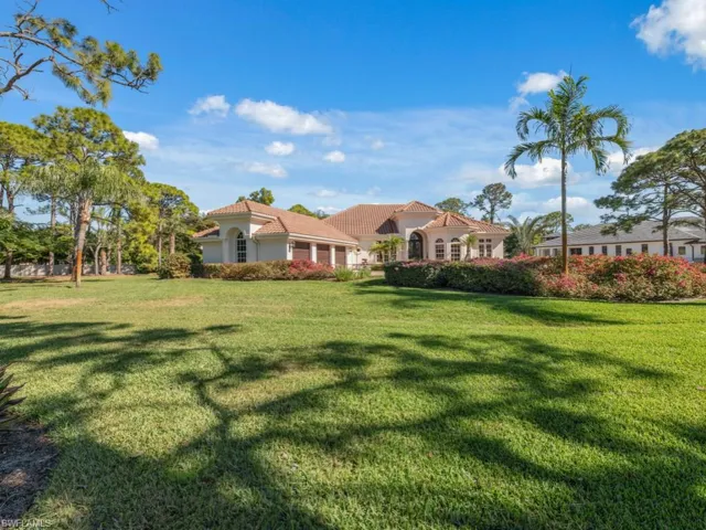View of grassy yard featuring a garage
