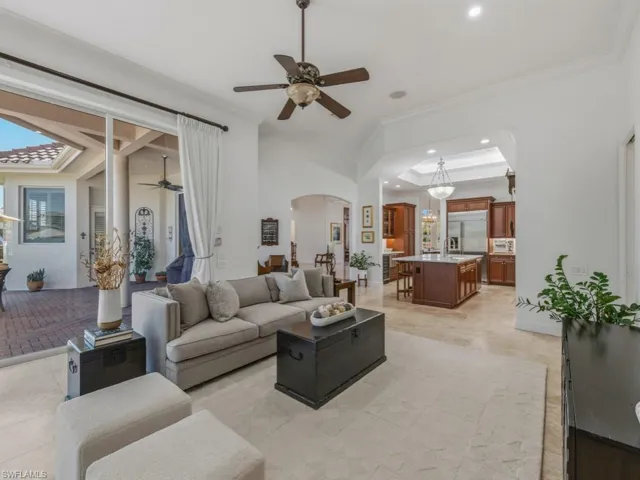 Living area featuring ceiling fan, arched walkways, ornamental molding, and recessed lighting