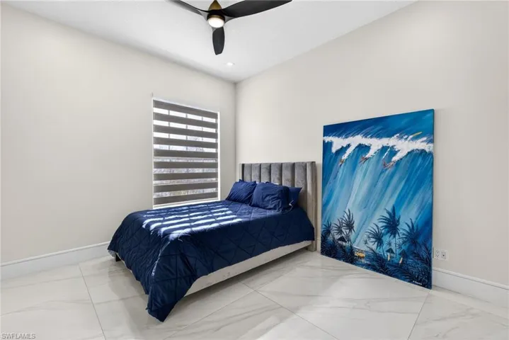 Bedroom with marble look tile flooring and ceiling fan