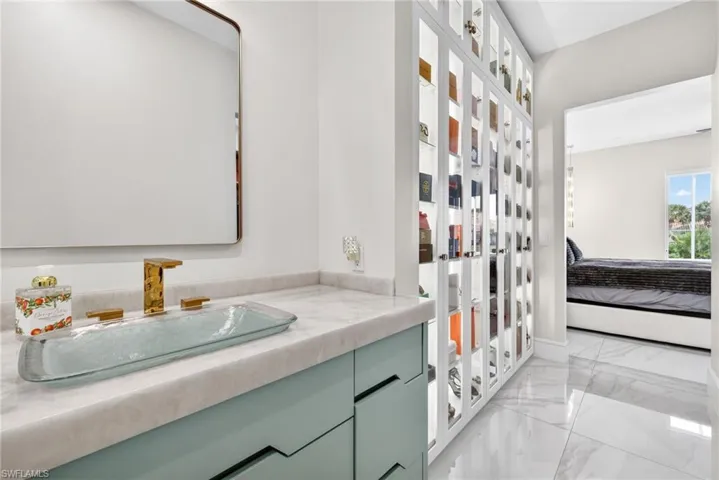 Bathroom with light marble finish floors, connected bathroom, vanity, and french doors