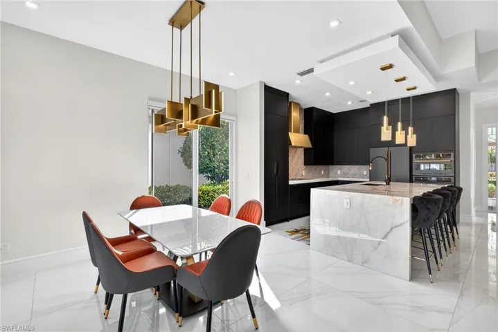 Dining space featuring recessed lighting, healthy amount of natural light, and light marble finish floors