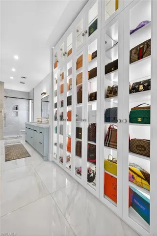 Hallway with light marble finish flooring and recessed lighting