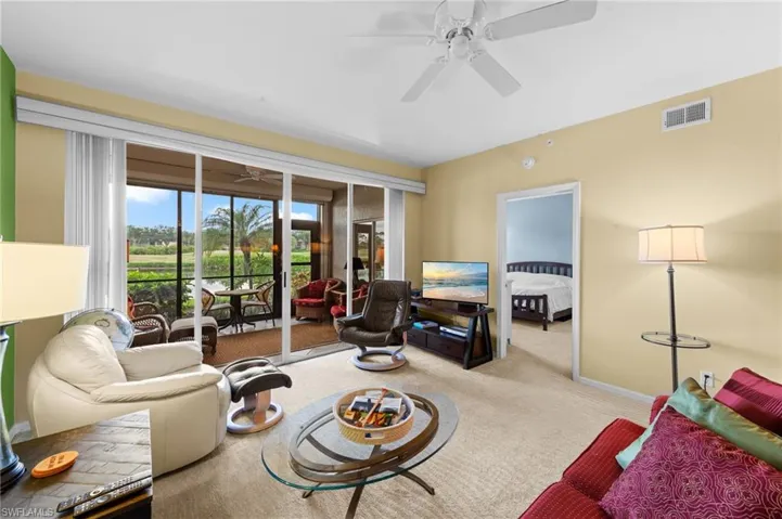 Living area featuring light carpet and a ceiling fan