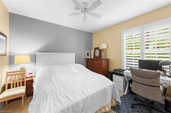 Bedroom featuring wood finished floors, a ceiling fan, and a desk
