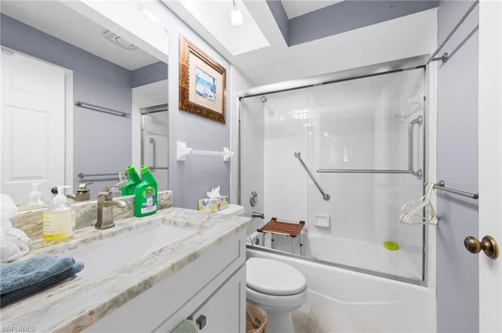 Bathroom featuring vanity, combined bath / shower with glass door, and tile patterned flooring