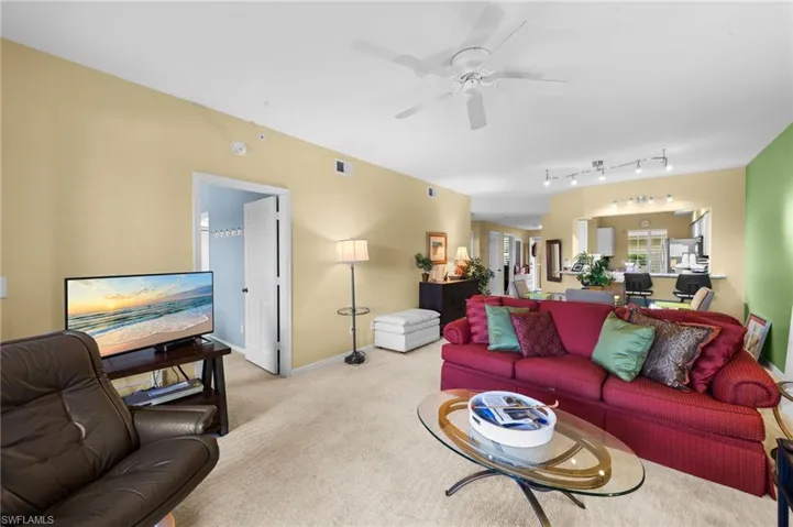 Living area featuring light carpet and a ceiling fan