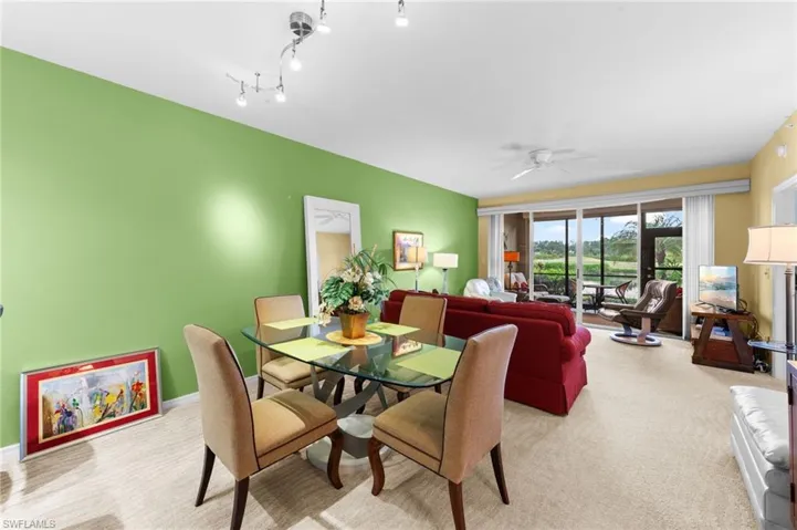 Dining space featuring light colored carpet and a ceiling fan