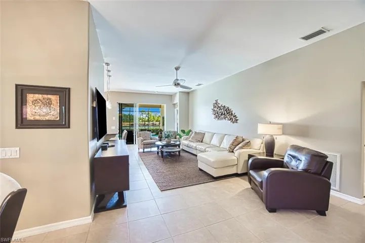 Living room with light tile patterned flooring and a ceiling fan