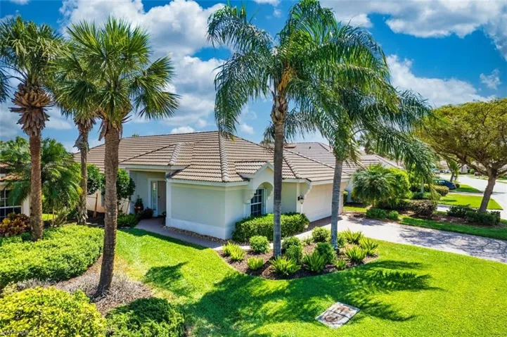 View of front of property featuring driveway, a front lawn, a garage, and stucco siding