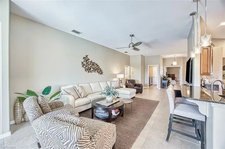Living area with light tile patterned floors and ceiling fan