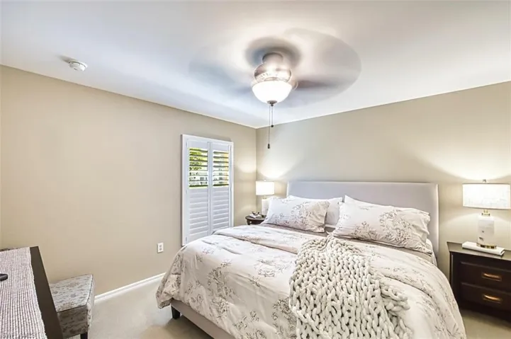 Carpeted bedroom featuring baseboards and ceiling fan