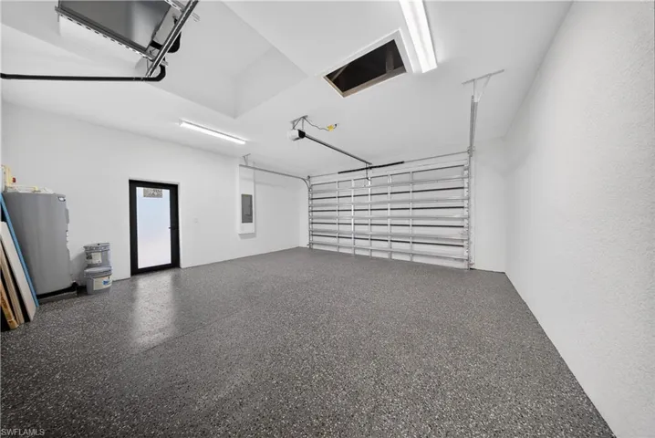 Garage featuring electric water heater and electric panel