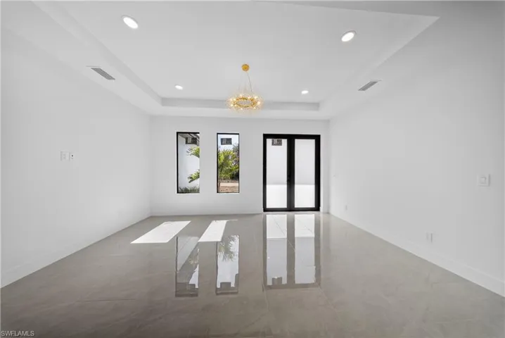 Spare room with hanging lights and a tray ceiling
