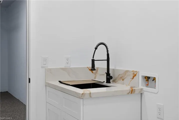 Detailed view of white cabinetry and light stone countertops