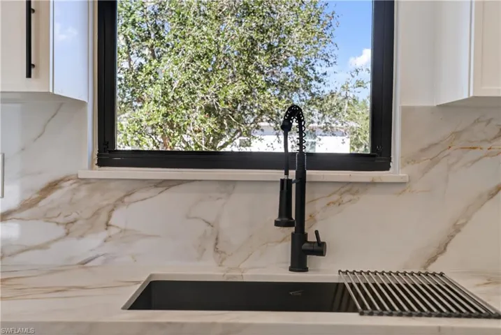 Kitchen view of white cabinetry and light stone counters