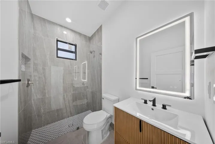 Bathroom with vanity, a shower stall, and recessed lighting