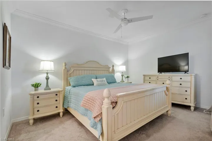 Bedroom featuring carpet flooring, ceiling fan, and crown molding