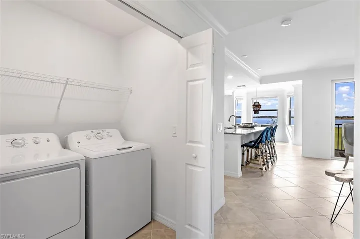 Laundry area with light tile patterned flooring and independent washer and dryer