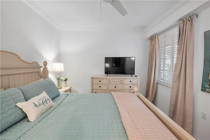 Bedroom with ceiling fan and ornamental molding